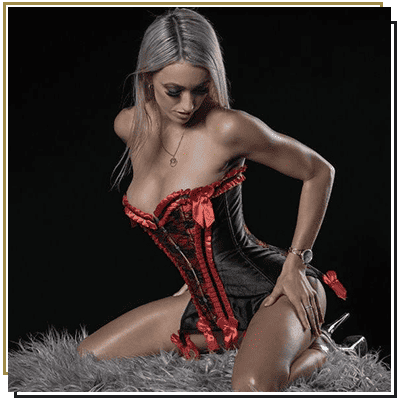 Evotique Stripper 2 blonde woman in black and red corsette posing on a cushion
